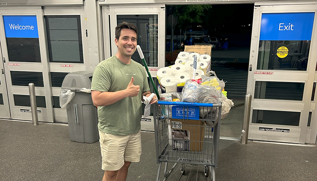 Man standing by a Full Shopping Cart