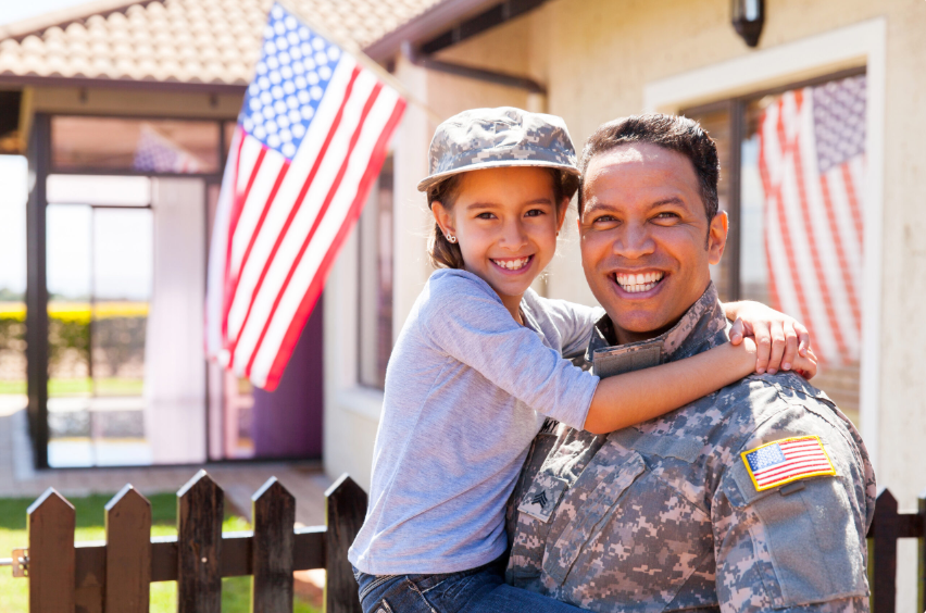Soldier father holding his young daughter